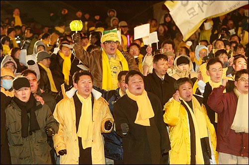 노사모 회원들이 19일 밤 서울 여의도 광장에서 열린 노무현 대통령 당선 1주년을 기념하는 '리멤버(Remember) 1219' 행사에서 임을 위한 행진곡을 부르고 있다. 